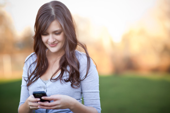 A portrait of a smiling beautiful woman texting with her phone