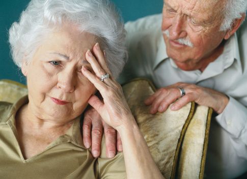 close-up of an elderly man consoling his wife