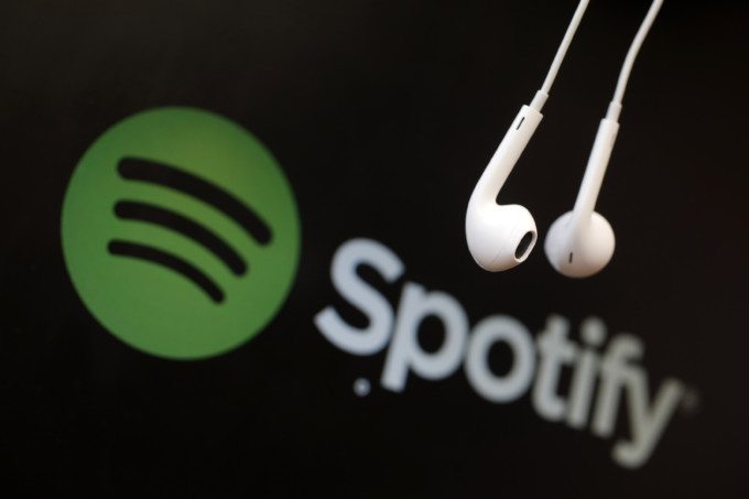 Headphones are seen in front of a logo of online music streaming service Spotify in this illustration picture taken in Strasbourg, February 18, 2014. Spotify is recruiting a U.S. financial reporting specialist, adding to speculation that the Swedish start-up is preparing for a share listing, which one banker said could value the firm at as much as $8 billion. REUTERS/Christian Hartmann (FRANCE - Tags: BUSINESS ENTERTAINMENT LOGO) - RTX1914U
